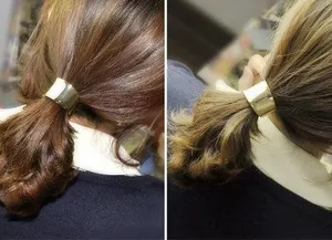 Polished gold metal ponytail cuff shown on hair with a smooth mirror finish
