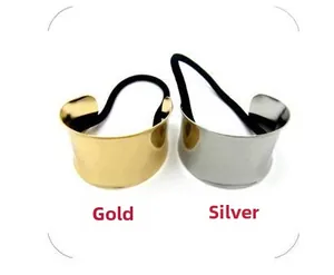 Detail of minimalist metallic hair ring set in gold and silver finish on white background