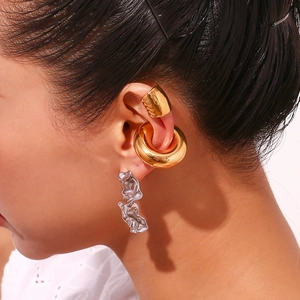Détail de bagues d'oreille en or 18K et boucles d'oreilles pendantes argentées irrégulières