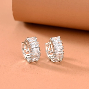 Detailed close-up of silver earrings featuring baguette-cut cubic zirconia and filigree patterns