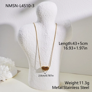 Vue macro d'un collier en acier inoxydable doré orné d'un pendentif en œil de tigre