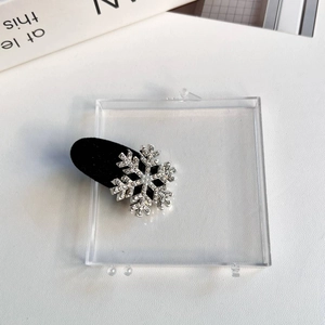 Détail d'une barrette flocon de neige en strass sur base en velours noir et métal argent