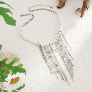 Detail of bohemian necklace with starfish pendant, shell fragments and long metal tassels