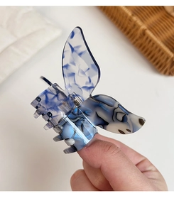 Detail of blue and white marble acetate butterfly hair claw with silver metal spring