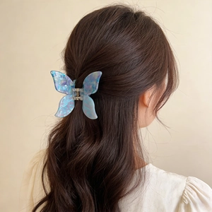 Chic 3D butterfly hair claw with iridescent blue and purple acetate finish on wavy hair