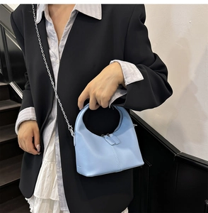 Sac hobo en cuir PU bleu clair avec bandoulière chaîne argentée porté par le mannequin