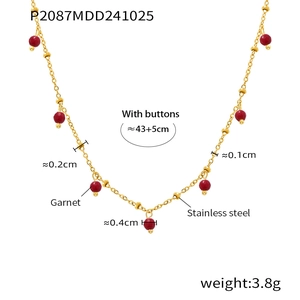 Macro detail of garnet beads and 18K gold plated stainless steel necklace chain