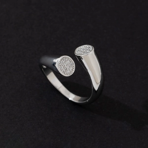 Detailed view of silver open ring featuring stone-paved circular ends on black surface