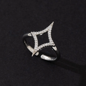 Close-up of minimalist four-pointed star ring with clear cubic zirconia pavé