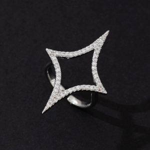 Detailed macro view of a silver four-pointed star ring with pavé-set stones