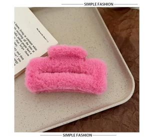 Detail showing plush rose pink faux fur hair claw clip on an aesthetic tray