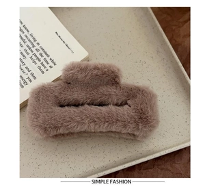 Detail of soft plush hair claw clip in dusty pink on a minimalist tray background