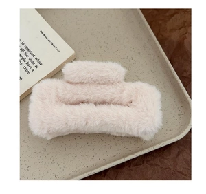 Detail of plush square hair claw clip in beige faux rabbit fur on minimalist tray