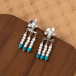 Detail of silver flower drop earrings with pearl tassels and turquoise beads