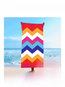 Detail of soft quick-dry beach towel with vibrant multi-color geometric wave patterns