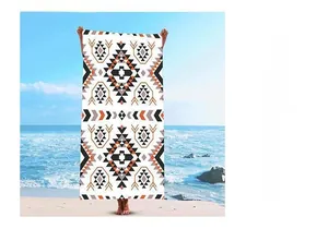 Detail of bohemian Aztec geometric print beach towel with orange and black pattern