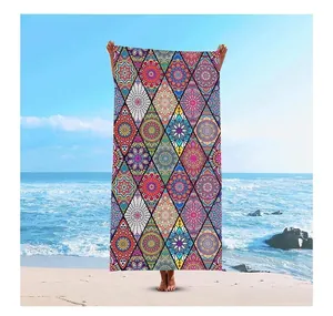Vibrant mandala geometric print beach towel displayed on a sunny outdoor coast