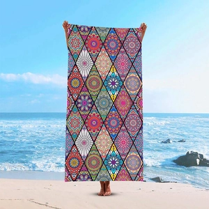 Bohemian geometric mandala print microfiber beach towel displayed on a sunny beach