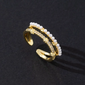 Close-up of gold double-layer ring with white pearls and sparkling cubic zirconia stones