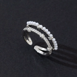 Detail view of a double-layered silver ring with white pearls and sparkling cubic zirconia