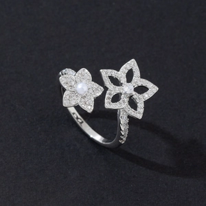 Detail of silver double flower ring with pearls and micro-pave diamonds on black background