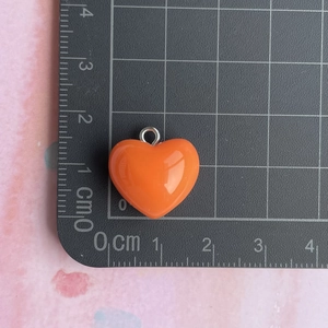 Detailed size view of an orange resin heart pendant measuring 1.5cm with silver ring hook