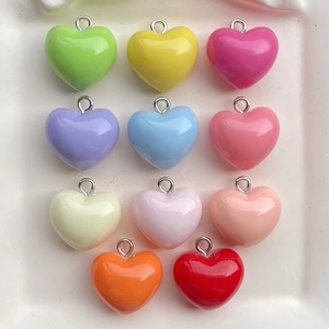 Detailed view of colorful resin heart charms with silver metal rings for DIY jewelry