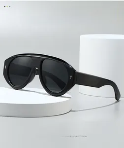 Détail de lunettes pilote noires oversize avec monture épaisse et rivets argentés en goutte
