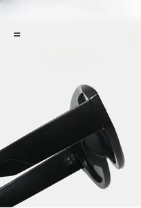 Détail de la monture de lunettes de soleil noires brillantes montrant sa texture élastique légère