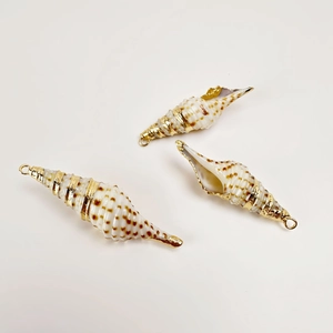 Close-up of three natural seashell charms with gold-plated edges for DIY jewelry making