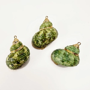 Detailed view of three natural conch shell pendants with gold plated caps and loops