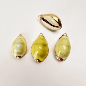 Detail of natural conch shell pendants with gold plated edges for DIY necklace jewelry