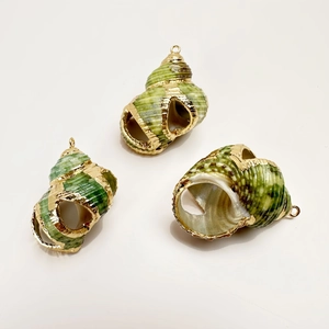 Detailed view of three natural conch shell pendants with gold plated edges and metal loops