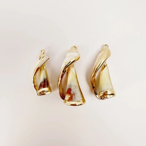 Detailed view of three natural shell pendants with golden electroplated metal edges
