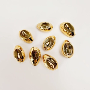Macro shot of eight gold-plated shell-shaped DIY jewelry pendants on white background