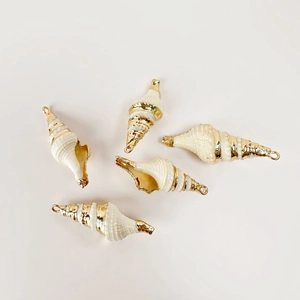 Detail of five natural white conch pendants with gold-plated edges for DIY jewelry making