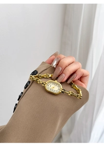 Elegant gold vintage quartz watch with an oval ivory dial and a chic link bracelet strap