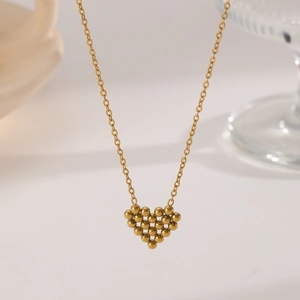 Collier doré avec pendentif cœur en perles métalliques sur une chaîne à maillons élégante
