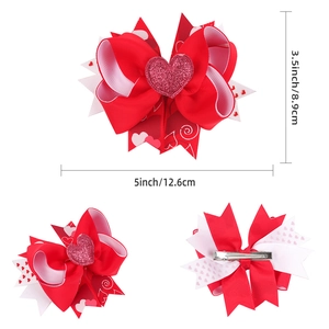 Detail of layered grosgrain bow hair clip with heart print and pink glitter center