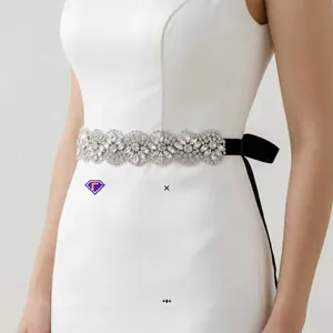 Detailaufnahme der handgenähten Strasssteine am schwarzen Brautgürtel aus Satin mit Blumenmuster