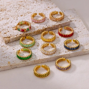 Adjustable gold rings set with colorful rectangular zircons on travertine stone