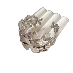 Silver wide asymmetrical open cuff bracelet with engraved floral and butterfly patterns