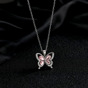 Détail du pendentif papillon argenté orné de zircons roses et de cristaux blancs