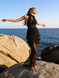 Sexy black lace halter maxi dress with floral neckpiece and ruffled hem at the seaside