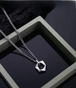 Gros plan du pendentif écrou hexagonal en acier titane avec chaîne à mailles gourmette