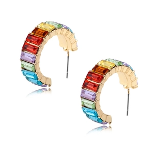 Detailed view of C-shaped gold earrings with rainbow baguette-cut gemstones in a row