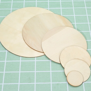 Set of natural round wooden slices for DIY crafts in various sizes on a cutting mat
