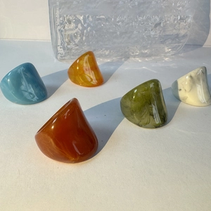 Detailed view of colorful acrylic chunky rings in blue amber marble and green tones