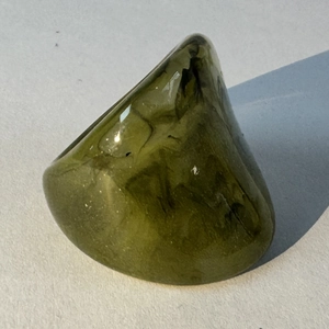 Macro shot of minimalist dark green acrylic resin ring with geometric triangular texture