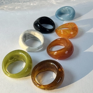 Selection of colorful acrylic resin rings with marble patterns in diverse vibrant shades